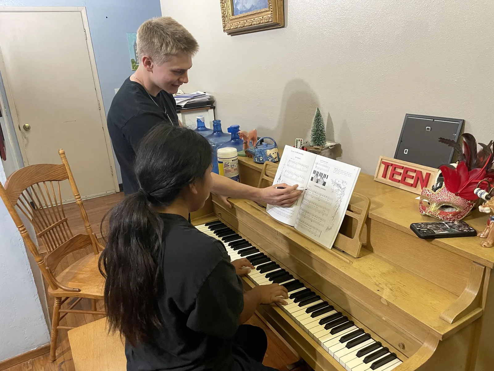 Austin Weaver teaching a piano student at the keys